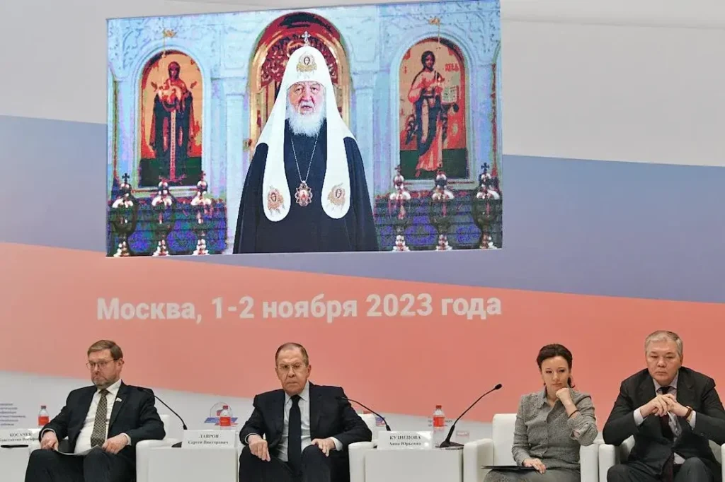 Онлайн-выступление патриарха Кирилла в ноябре 2023 на конференция «Укрепление традиционных духовно-нравственных ценностей — залог единства российских соотечественников» в Москве. Внизу слева направо: зампред Совета Федерации России Константин Косачев, министр иностранных дел России Сергей Лавров, зампред Госдумы России Анна Кузнецова и Леонид Калашников. Фото: Евгений Разумный/Коммерсантъ.
