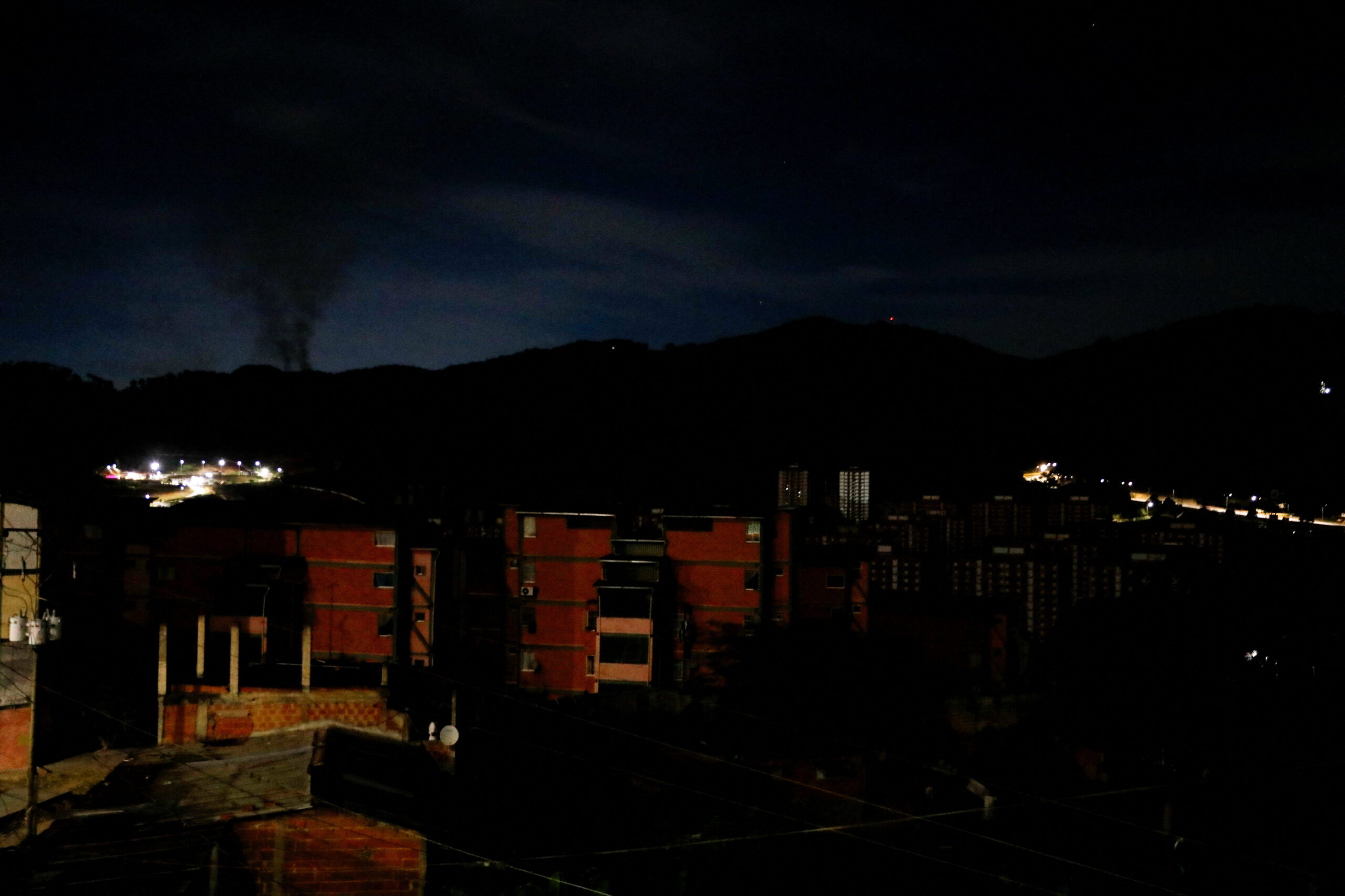 Столб дыма над обезсточенным Каракасом во время операции США в Венесуэле 3 января 2026 года