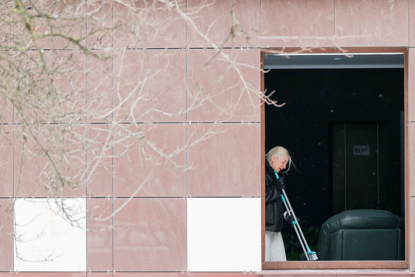 Жительница Белгорода убирает остатки разбитых окон в одном из торговых центров города